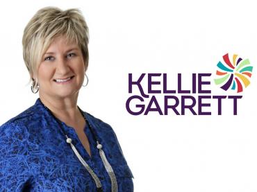 Corporate Photo Of Kellie Garrett On White Background With Her Name And Logo Beside Her